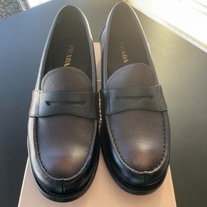 PRADA Saffiano Cuir black and brown penney loafers.